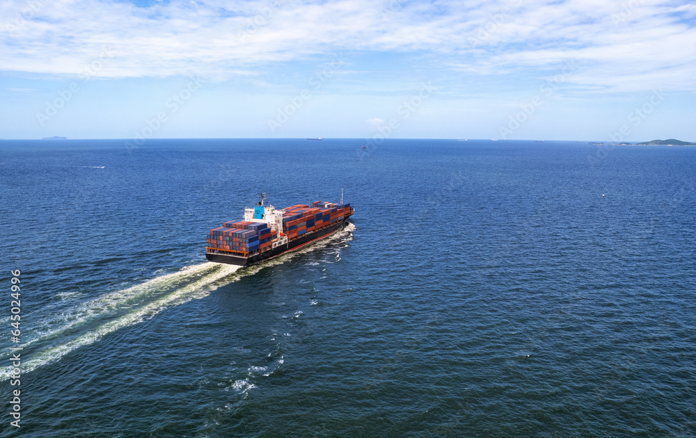 Aerial top view container ship full load container for logistics import export, shipping or transportation  shipyard at sunrise, logistic import export and transport industry background