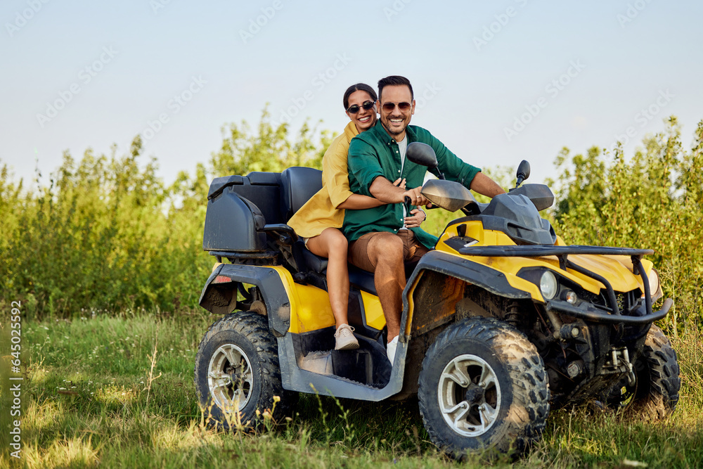 Portrait of a smiling love couple on a rental quad bike during an off-road ride. Portrait of a smiling love couple on a rental quad bike during an off-road ride.