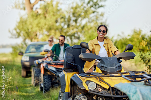 Portrait of a happy woman enjoying a quad bike ride with her friends.