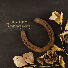 Happy Thanksgiving rustic background for western holiday banner with flat lay of rusty horseshoes and fall leaves.