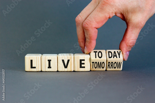 Live today not tomorrow symbol. Businessman turns wooden cubes and changes word Live tomorrow to Live today. Beautiful grey background. Business and live today not tomorrow concept. Copy space.