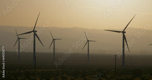 Wind turbines, windmills spinning in a field near Palm Springs San Gorgonio Pass. Mountains in background