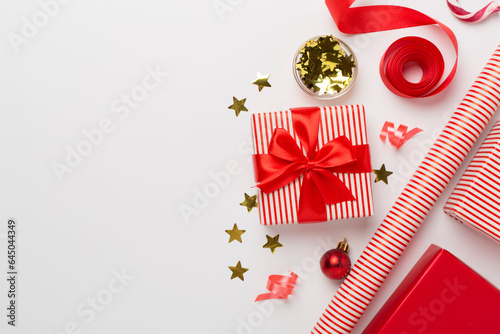 Gift boxes with paper's rools and christmas decoration on color background, top view