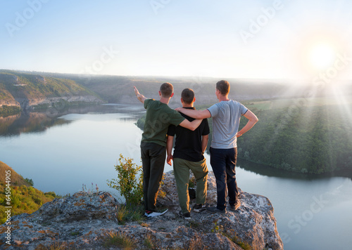 Three friends look at the valley