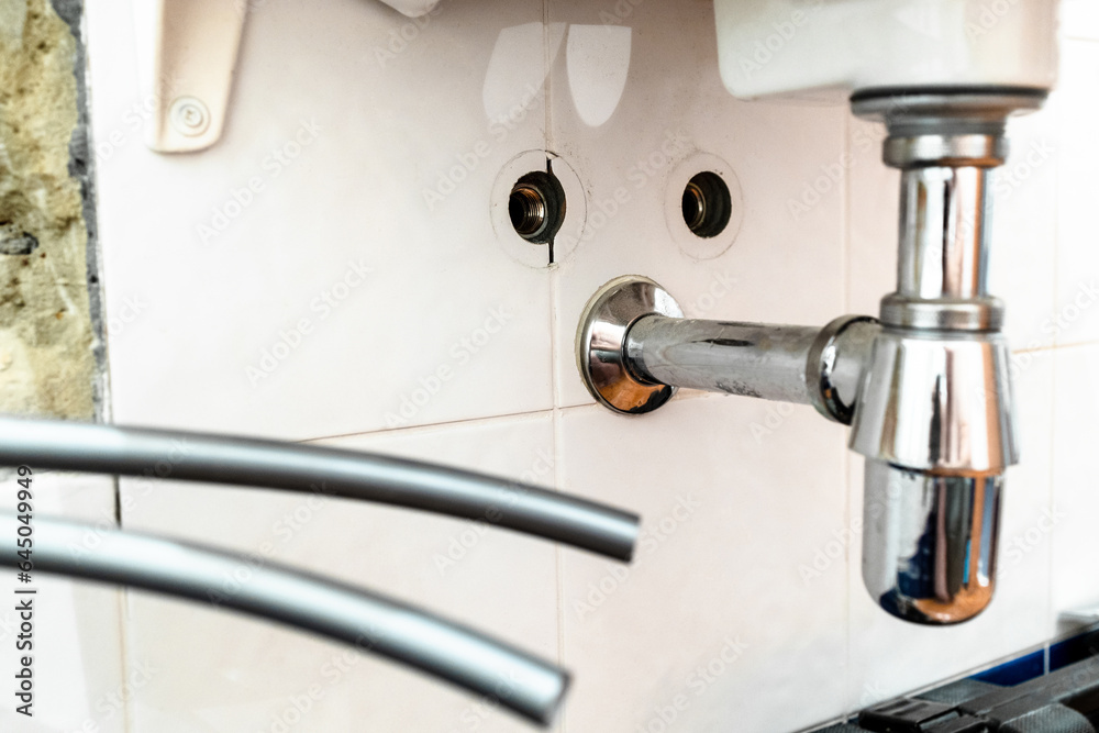 installation of new polyethylene flexible water pipes to faucet on sink (focus on the siphon) during installation of new water supply in bathroom installation of new polyethylene flexible water pipes to faucet on sink (focus on the siphon) during installation of new water supply in bathroom