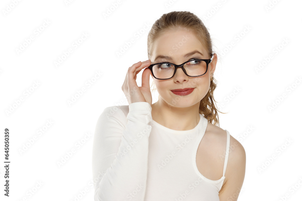 Portrait of beautiful smiling thinking blonde woman wearing glasses on a white studio background