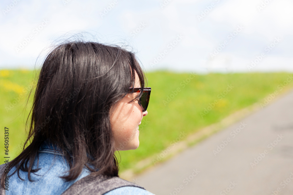 Portrait of a beautiful brunette woman in sunglasses and backpack on a sunny day Portrait of a beautiful brunette woman in sunglasses and backpack on a sunny day