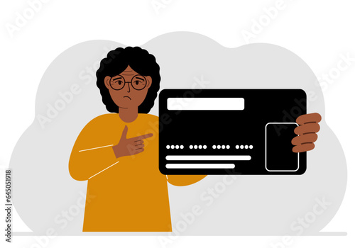 A woman holds a large plastic credit card in his hand.