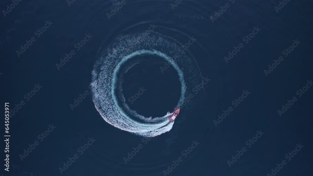 Luxury boat forms a circle of waves with its engines over the sparkling