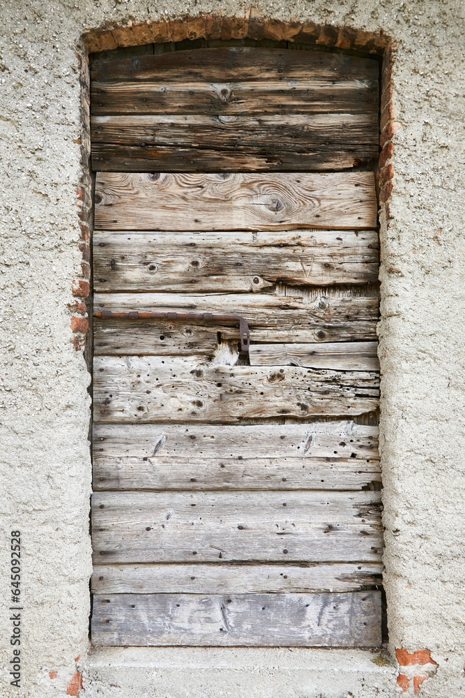 Old stable door with beautiful grain on a farmhouse in Tuscany, Italy. Detail.