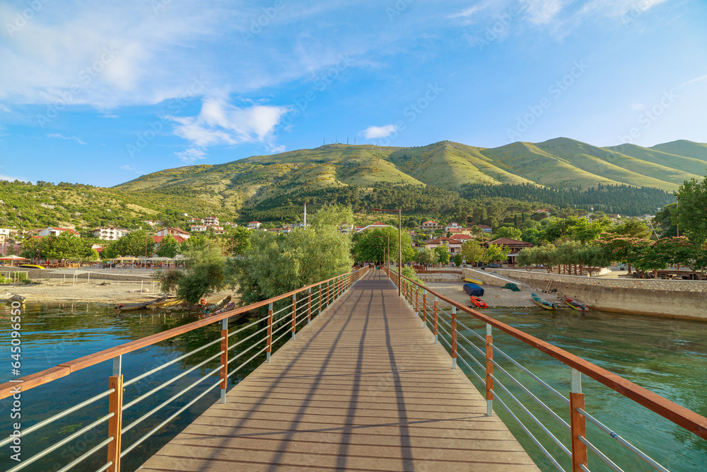 A picturesque wooden jetty on Shkodra Lake in Shkoder town of Albania. Shkodra wharf extends gracefully into the tranquil waters of Shkoder lake, offering a serene spot for lakeside relaxation and