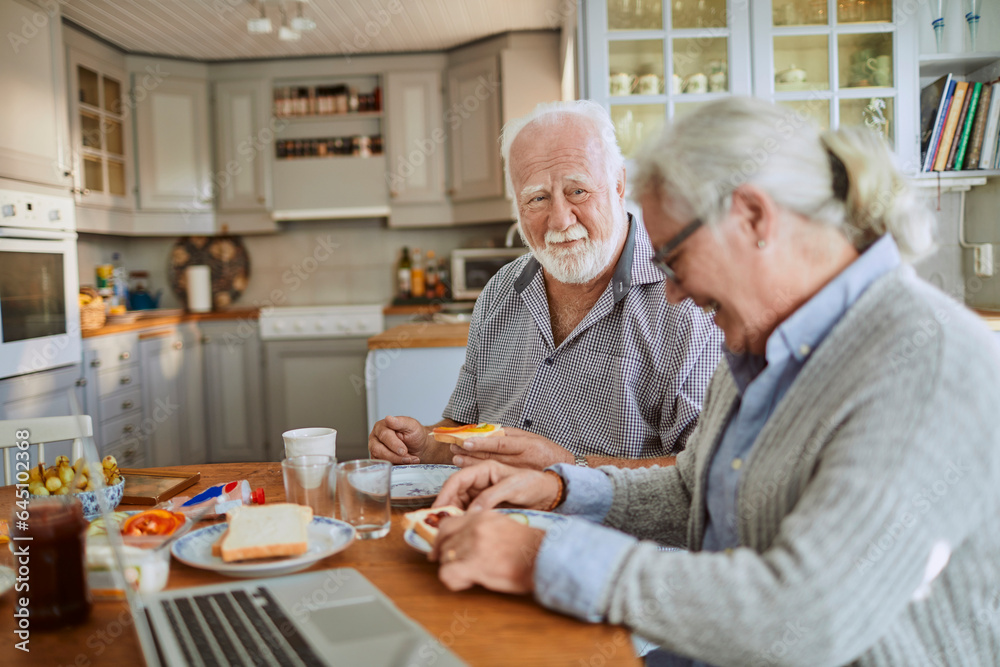 Senior Caucasian couple having breakfast together in the kitchen in the morning Senior Caucasian couple having breakfast together in the kitchen in the morning