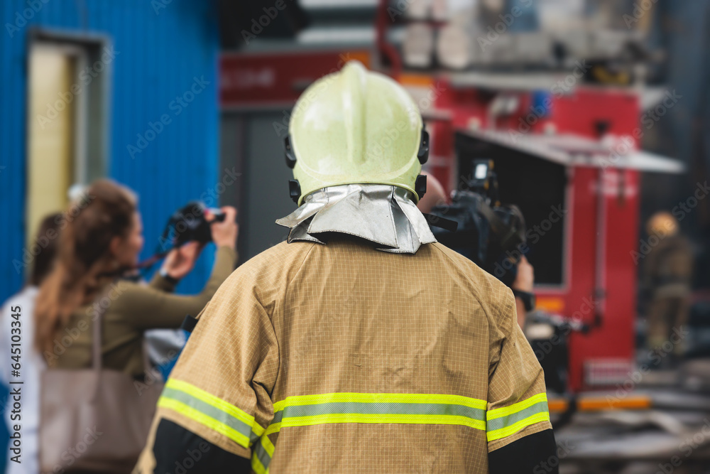 Group of fire men in protective uniform during fire fighting operation in the city streets, firefighters brigade with the fire engine truck vehicle in the background, emergency and rescue service Group of fire men in protective uniform during fire fighting operation in the city streets, firefighters brigade with the fire engine truck vehicle in the background, emergency and rescue service