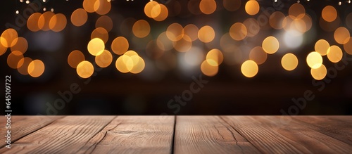 Restaurant background with blurred lights bokeh on an empty wooden table top.