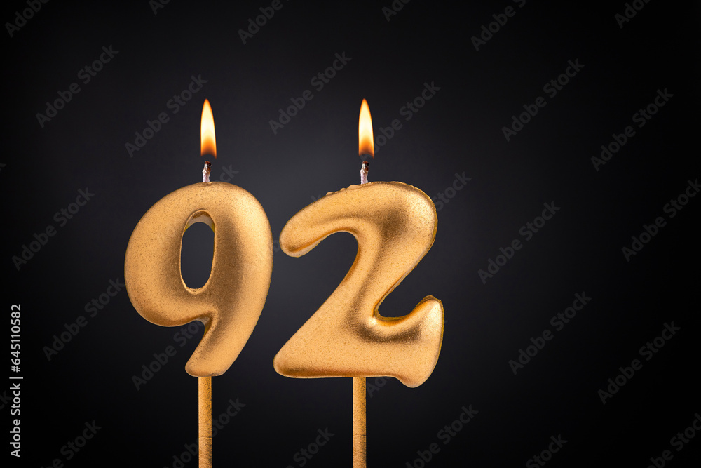 Golden candle 92 with flame - Birthday card on dark luxury background Golden candle 92 with flame - Birthday card on dark luxury background