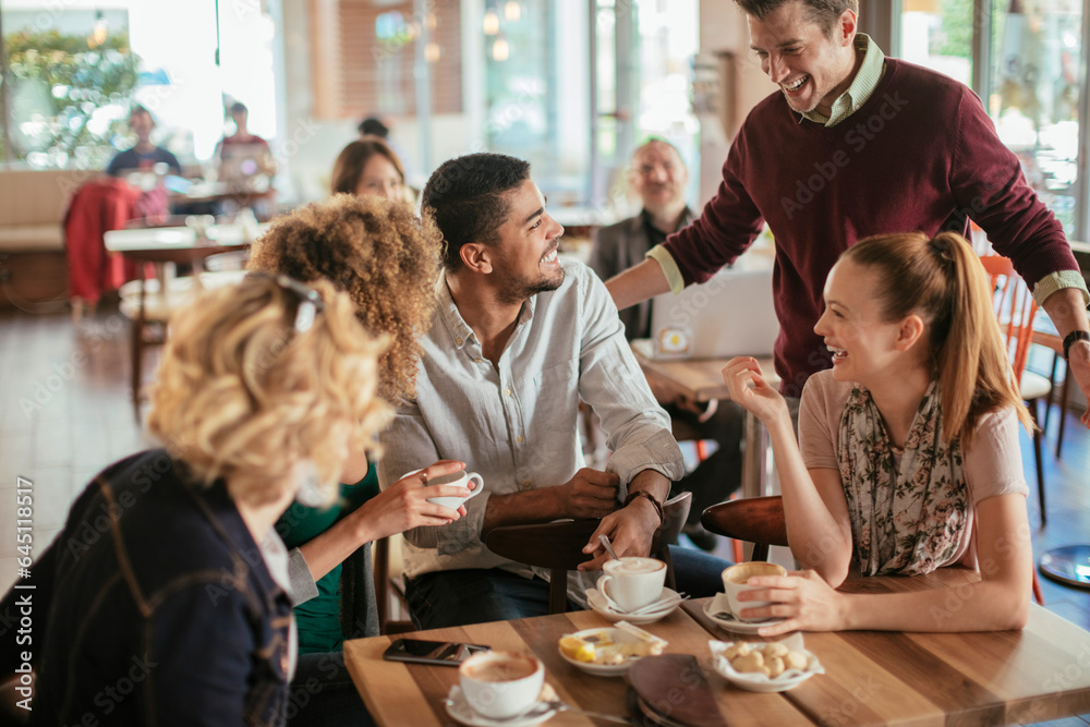 Young and diverse group of people talking while having coffee together in a cafe Young and diverse group of people talking while having coffee together in a cafe