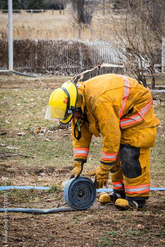Volunteer Firefighter rolling up a hose