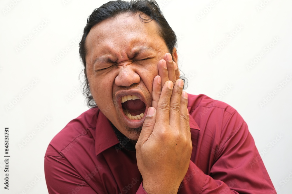 Obraz premium Adult Asian man touching his jaw with pain expression