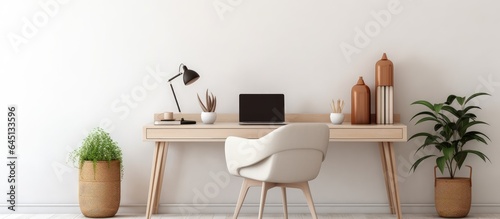 Modern office with laptop, cozy chair, and white wall.