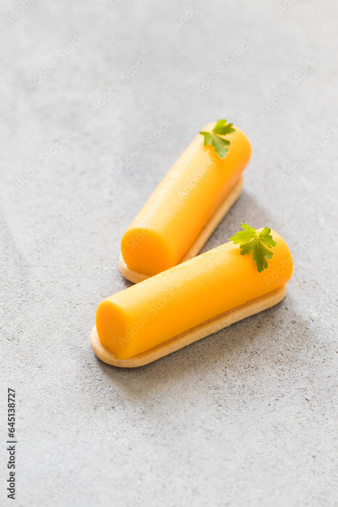 Two Carrot cream cakes of cylindrical shape, dessert bar. On cookies. Light gray background Two Carrot cream cakes of cylindrical shape, dessert bar. On cookies. Light gray background