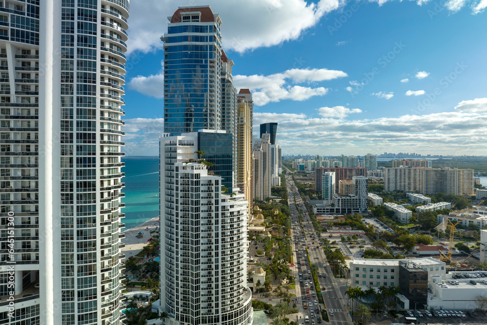 Aerial view of Sunny Isles Beach city with congested street traffic and luxurious highrise hotels and condos on Atlantic ocean shore. American tourism infrastructure in southern Florida