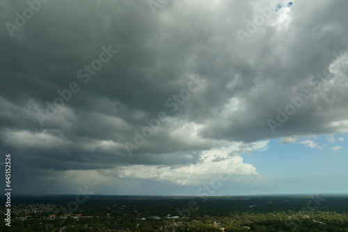 Dark stormy clouds forming on gloomy sky before heavy rainfall over suburban town area