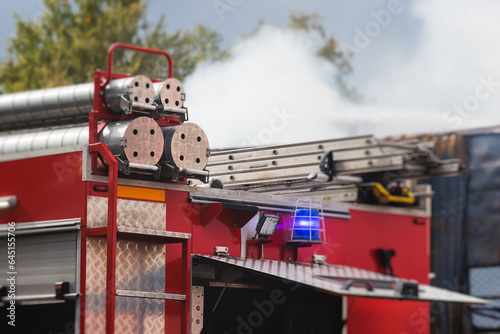Fire fighting equipment in the city, with red fire engine truck during fire fighting operation in the city streets, vehicle and firefighters extinguish blaze, emergency and rescue service vehicle