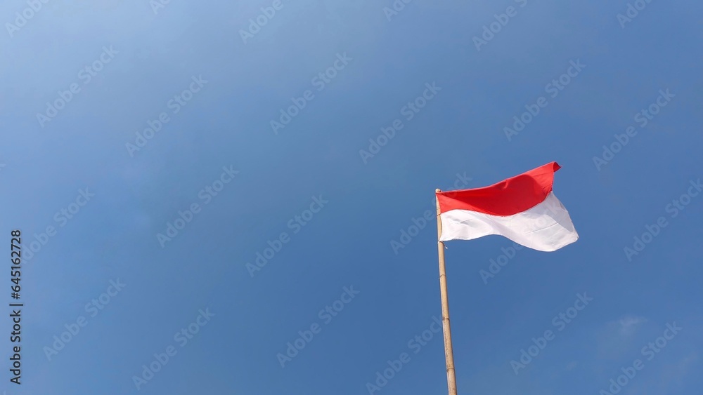 Indonesian flag. Red and white flag. In blue sky