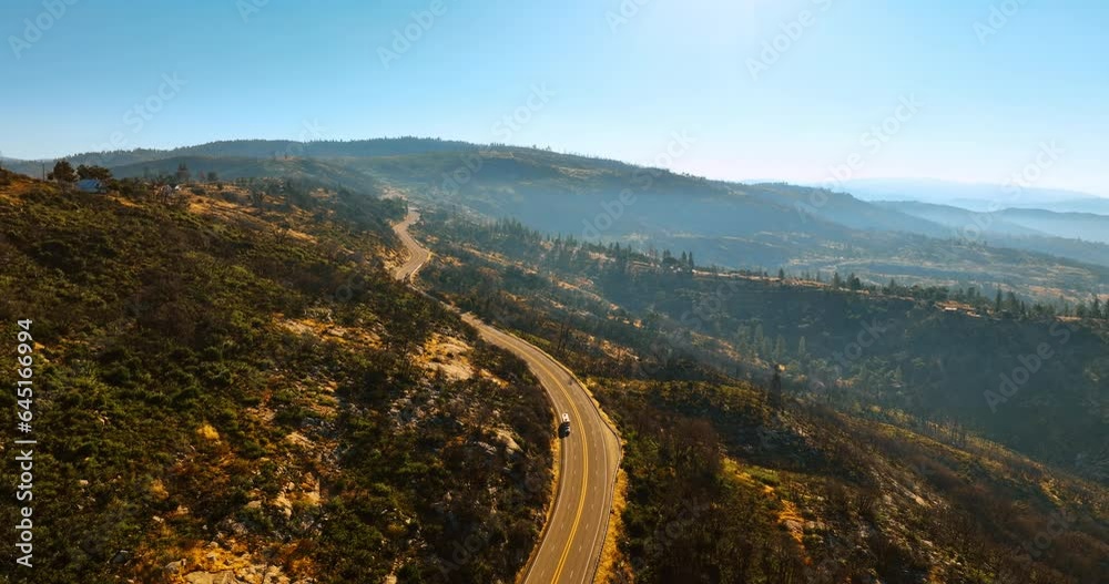 Flight over the highway in the mountains of Sierra National Forest, USA. Beautiful sunny scenery from top view. Flight over the highway in the mountains of Sierra National Forest, USA. Beautiful sunny scenery from top view.