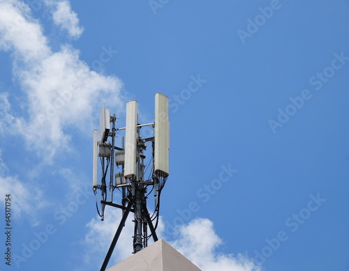 Telecommunication tower of 4G and 5G cellular. Macro Base Station. 5G radio network telecommunication equipment with radio modules and smart antennas mounted on a metal against cloulds sky background. photo