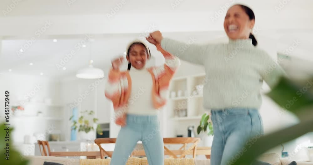 Mother, girl child and dancing in home with energy, crazy fun and happy freedom together. Excited mom, young kid and jump on couch for party celebration, play and love of dance music in living room Mother, girl child and dancing in home with energy, crazy fun and happy freedom together. Excited mom, young kid and jump on couch for party celebration, play and love of dance music in living room