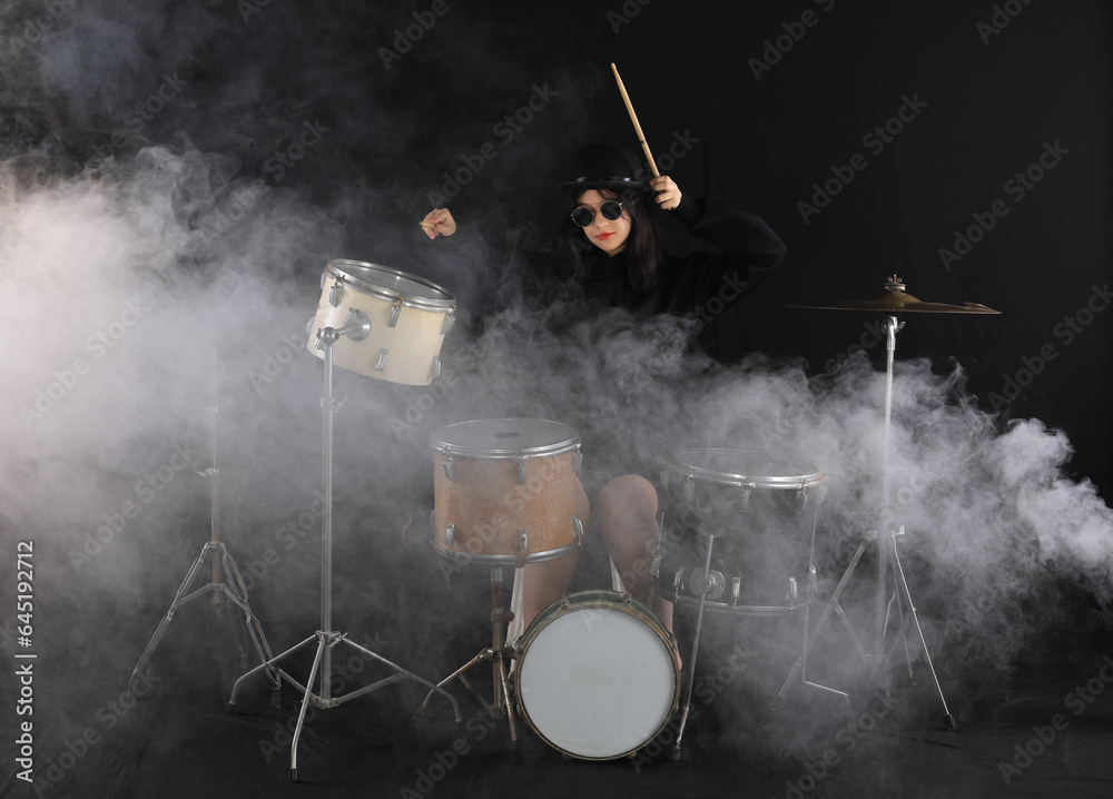 girl plays drums on a black background girl plays drums on a black background