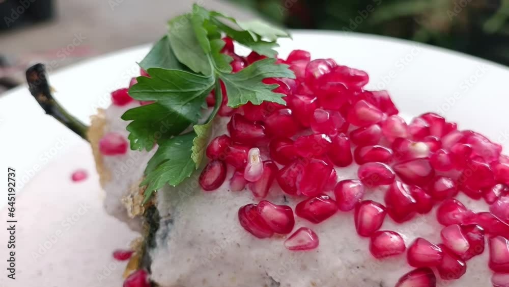 Parsley and pomegranate on a Mexican chile en nogada