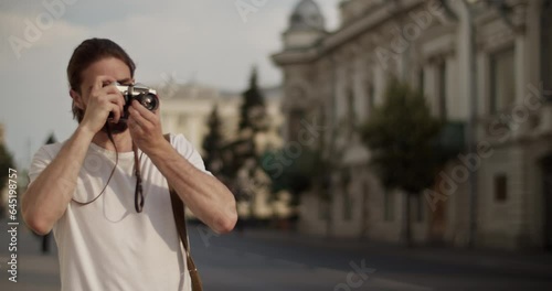 Male tourist taking photos on city street during trip