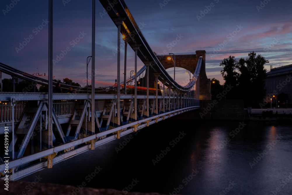Fototapeta premium Panoramic evening view on Wroclaw Old Town. Silhouette of Island and Cathedral of St John with bridge through river Odra. Wroclaw, Poland. Grunwaldzki bridge over the Odra river