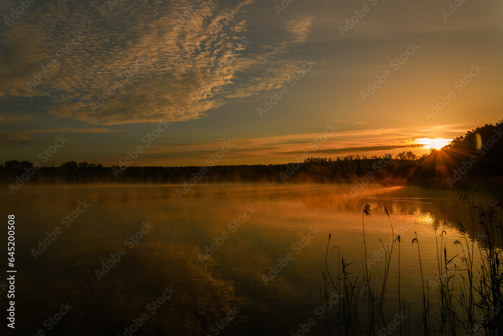 colorfull sunrise over pond with mist