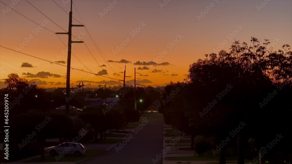 Deep orange sunset in suburban Perth Western Australia. Looking down street to clouds on horizon with powelines. Deep orange sunset in suburban Perth Western Australia. Looking down street to clouds on horizon with powelines.