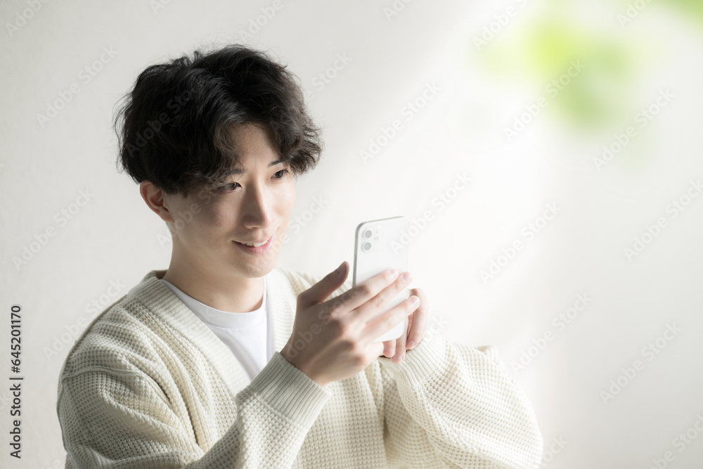 Asian (Japanese) male operating a cell phone Tap Asian (Japanese) male operating a cell phone Tap