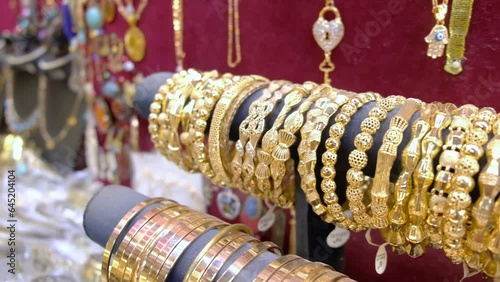 Row of golden jewelry bracelets at traditional middle eastern bazaar photo