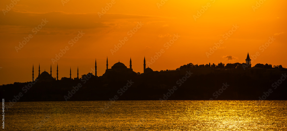 Eminonu city with mosque silhouettes in the background at sunset