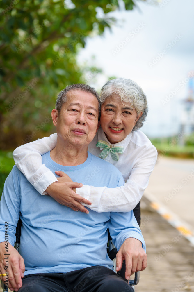 Nature harmony, Asian elderly couple happiness in the outdoor park, Elderly husband on wheelchair, wife caregiving, park outdoor, happy family, grey hair, hug, kiss