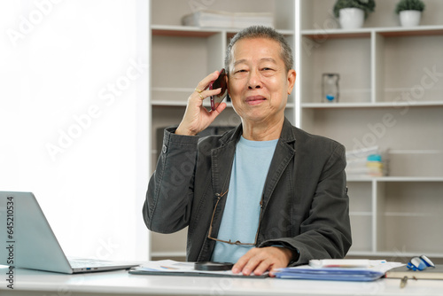 Mature businessman diligently working at his office desk, demonstrating dedication and commitment to his tasks. Experienced executive, Corporate competence, Executive commitment, Business maturity
