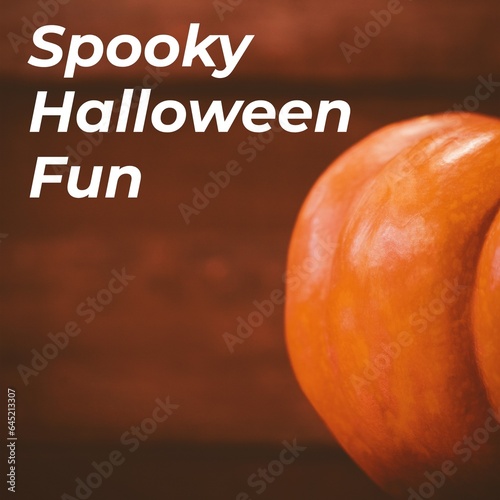 Composite of spooky halloween fun text and halloween pumpkin on brown background