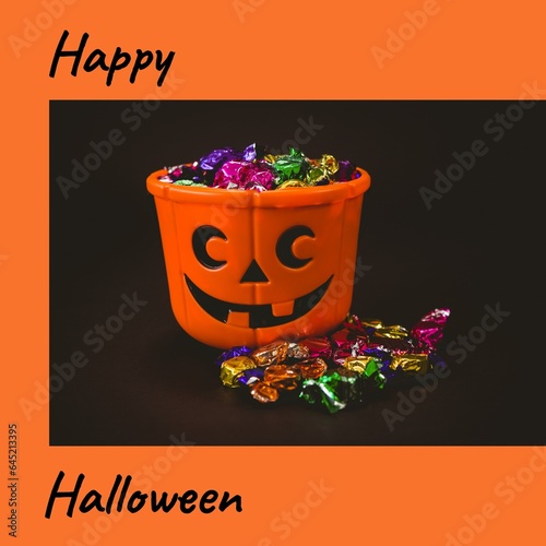 Composite of happy halloween text and halloween pumpkin bucket on orange background