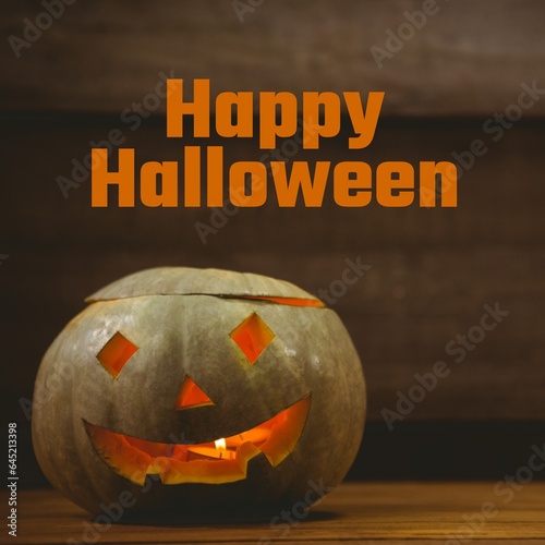 Composite of happy halloween text and halloween pumpkin on brown background
