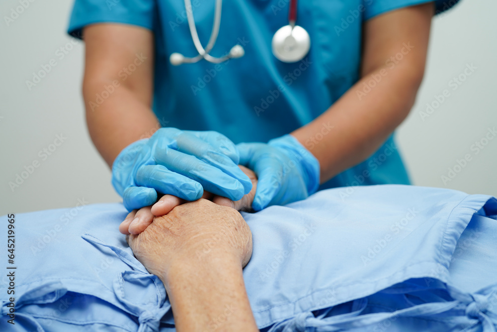 Obraz premium Doctor holding hands Asian elderly woman patient, help and care in hospital.