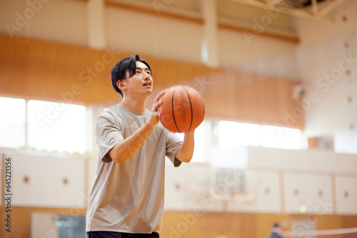体育館でバスケットボールの練習をする日本人高校生の男性 photo