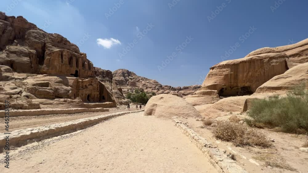 Petra valley in Wadi Musa, Jordan with The Treasury in the middle of a rocky and mountainous landscape, an UNESCO heritage site, ancient Nabatean Kingdom 4K Establish Shot Petra valley in Wadi Musa, Jordan with The Treasury in the middle of a rocky and mountainous landscape, an UNESCO heritage site, ancient Nabatean Kingdom 4K Establish Shot