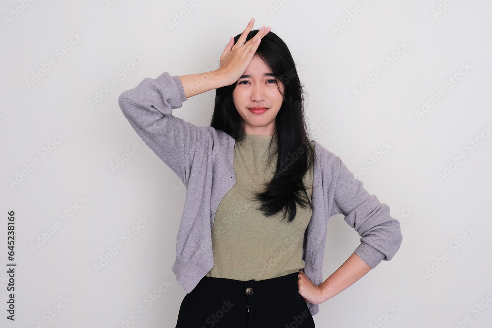 Young Asian woman touching her forehead showing sad expression Young Asian woman touching her forehead showing sad expression
