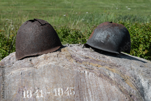 Foto Old rusty military helmet with holes lie at the memorial world war years 1941 19